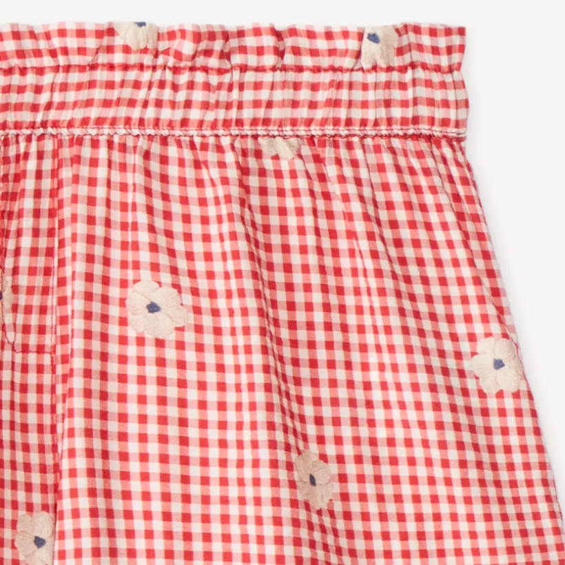 Kort meisje met vichy-stijl en geborduurde bloemen