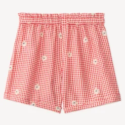 Kort meisje met vichy-stijl en geborduurde bloemen
