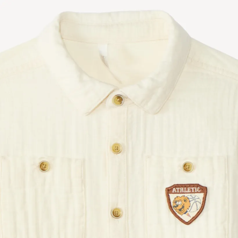 Langarmige babyjongen blouse van dubbele gaze met een fantasiebadge.