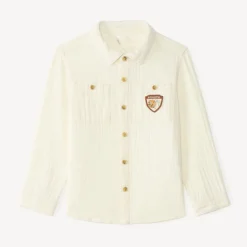 Langarmige babyjongen blouse van dubbele gaze met een fantasiebadge.