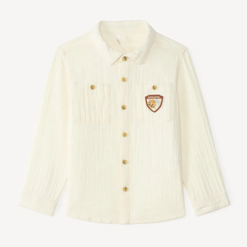 Langarmige babyjongen blouse van dubbele gaze met een fantasiebadge.