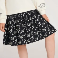 Meisjes jurk van twee materialen met lange mouwen en geborduurde bloemen.