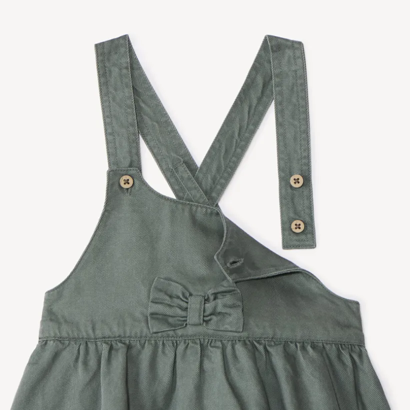 Overgooierjurk met gekruiste bretellen en knoop voor babymeisje