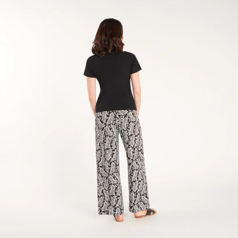 Wide and flowing pants with a high printed waistband for pregnant women.