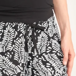 Wide and flowing pants with a high printed waistband for pregnant women.